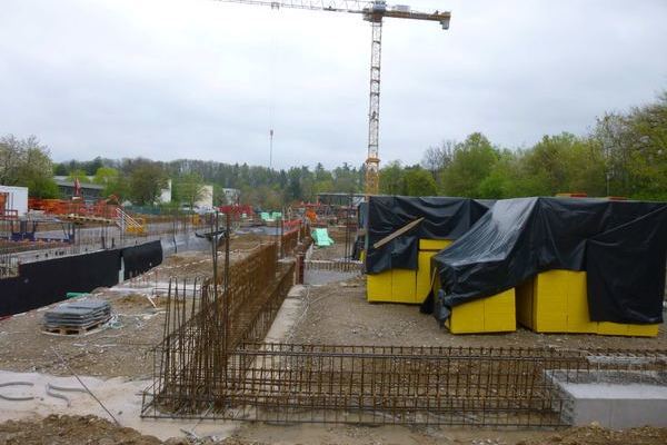 Baustelle mit Fundamentbewehrung und Baukran
