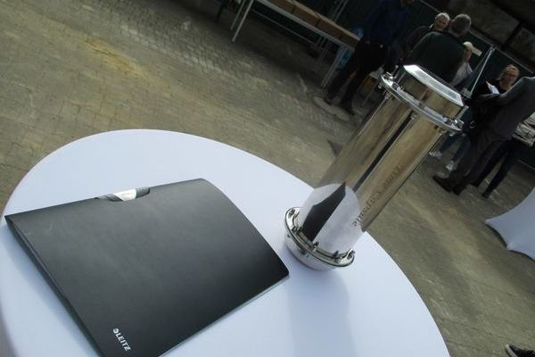 schwarze Projektmappe und die Zeitkapsel auf rundem Tisch